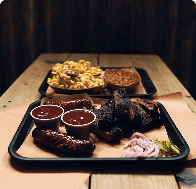 Barbecue platter with sides on wooden table.